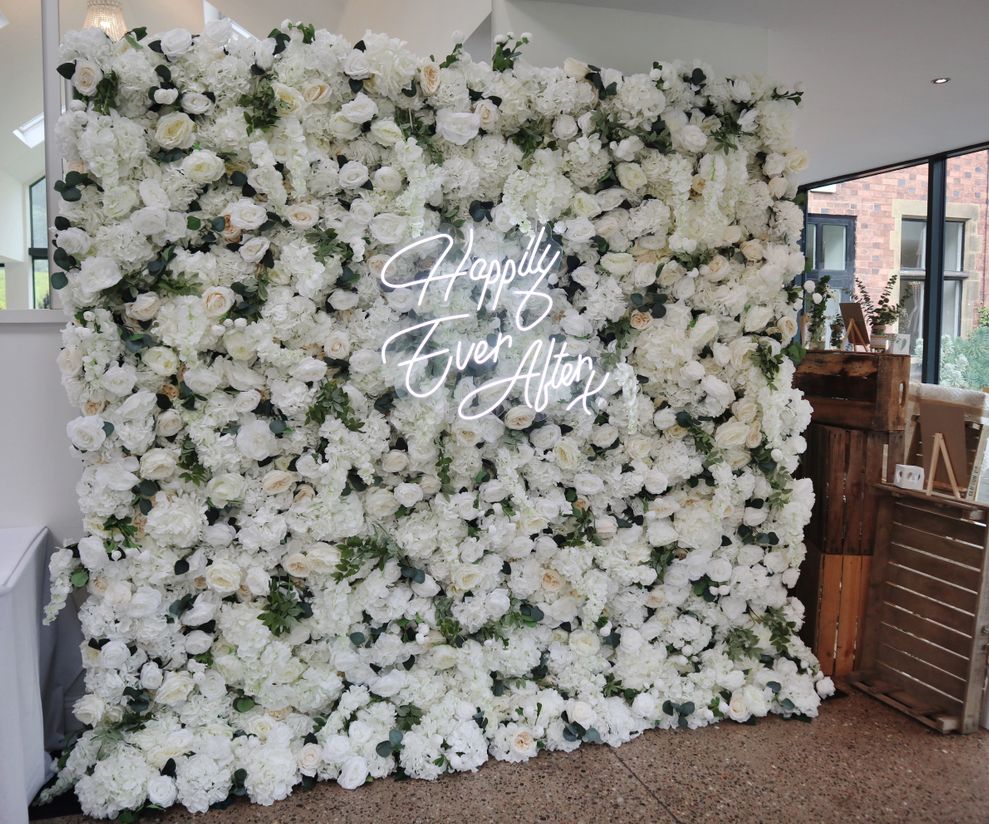 White flower wall hire with foliage and wedding neon sign Cheshire