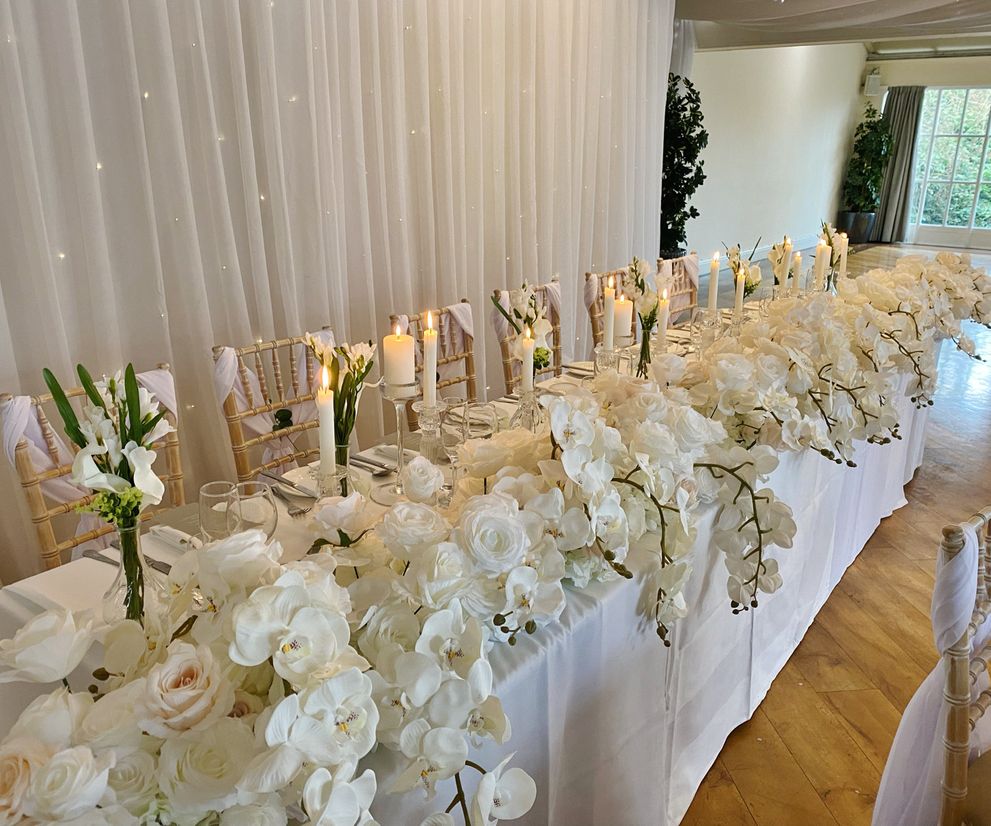 White rose rop table flowers with orchids wedding table styling 