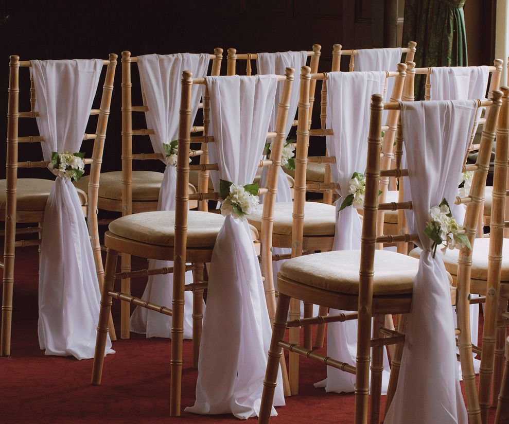 White chiffon wedding chair drapes with flowers to hire in Cheshire
