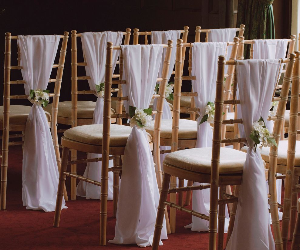 White chiffon wedding chair drapes with flowers to hire in Cheshire