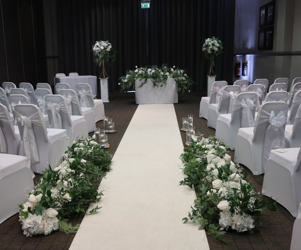 Ceremony aisle floral decor with chair covers and bows in Manchester